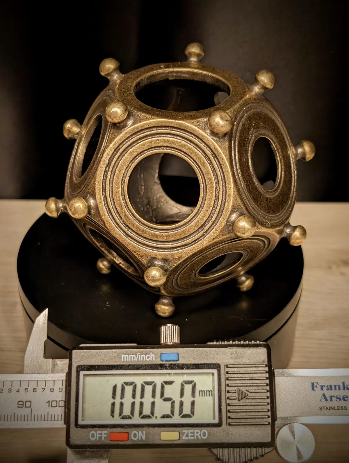 Digital caliper reading 100.50 mm across the metal dodecahedron